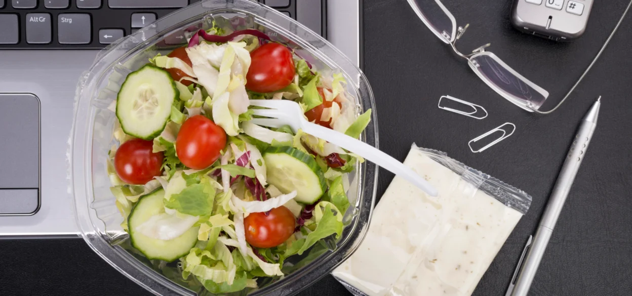 Laptop on a desk and a salad