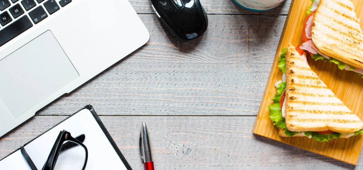 Laptop on desk with toasted sandwich