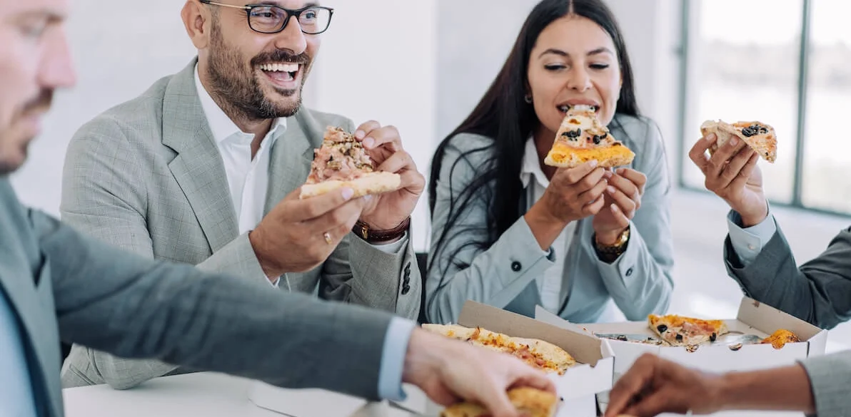colleagues eating pizza at the table